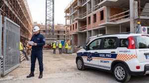 Operatore Vigil Pro Security con auto di servizio Fiat Panda brandizzata al varco di un cantiere a Milano